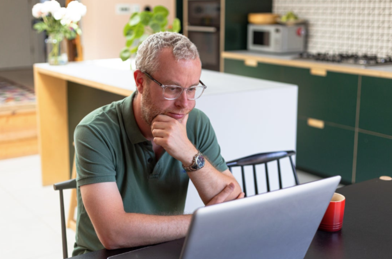 Man on a laptop, reading 
